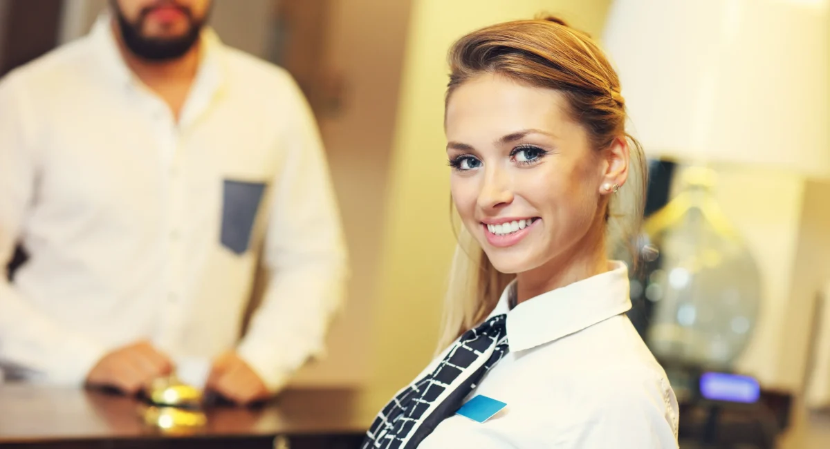 Glückliche Rezeptionistin bei ihrem Jobs Obertauern bei Ferienwohnungen und Apartments Alpenrose