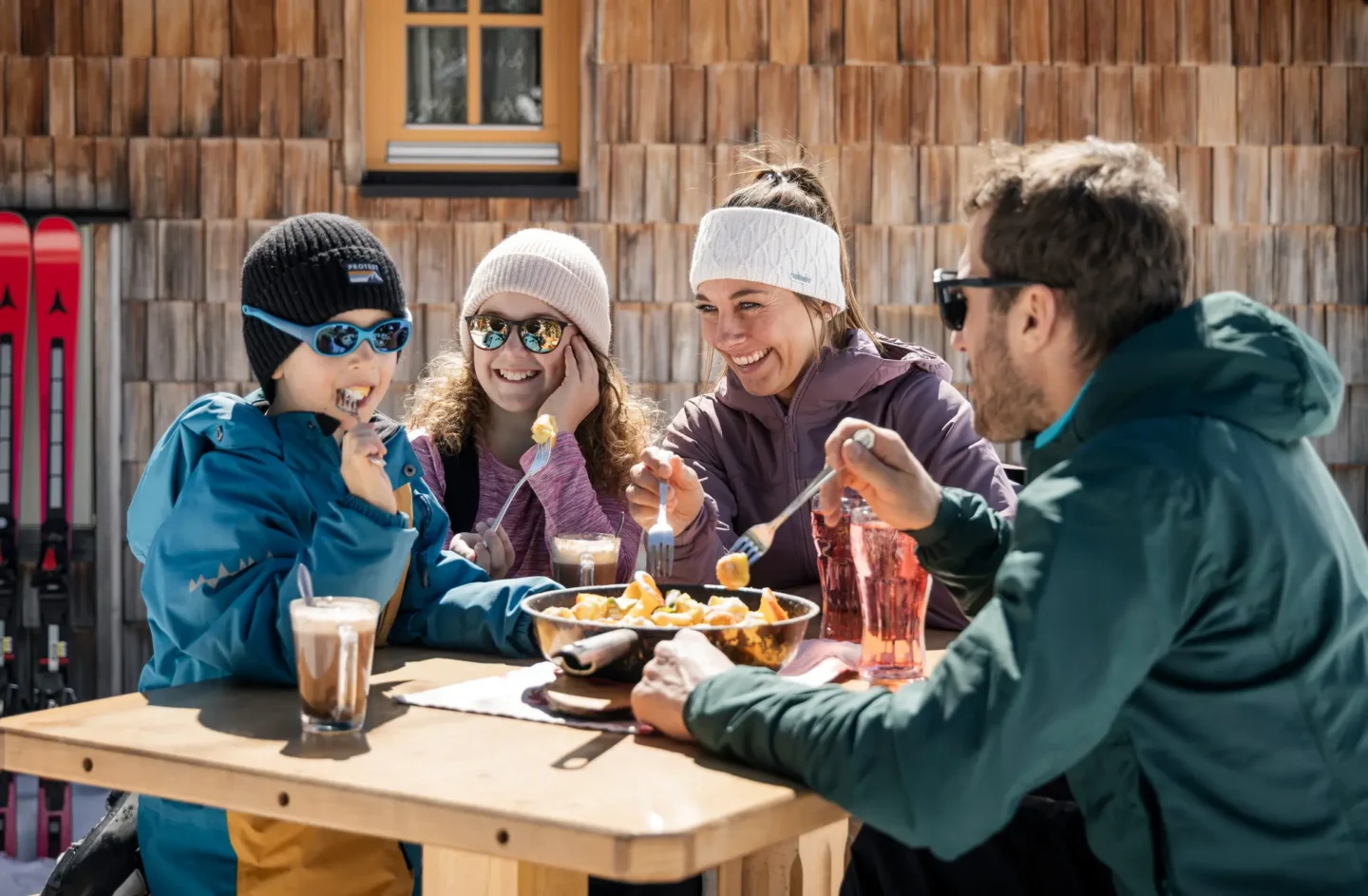Familie auf Almhütte beim Essen von Kaiserschmarrn